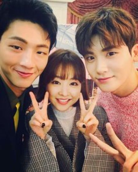 Hyung-Sik (right) and Bo-Young (middle) raising one and two hands respectively in peace sign.
